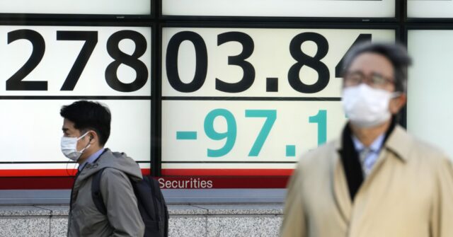 japan financial markets people walk an electronic stock board japan nikkei 225 front of securi